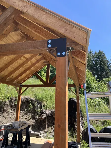 Timber porch frame up, a black steel bracket ties the post to the beam.